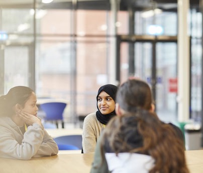 Three sixth form students sitting together in the Sixth form building