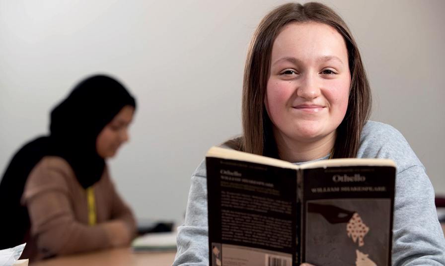 student reading book - Othello smiling to camera