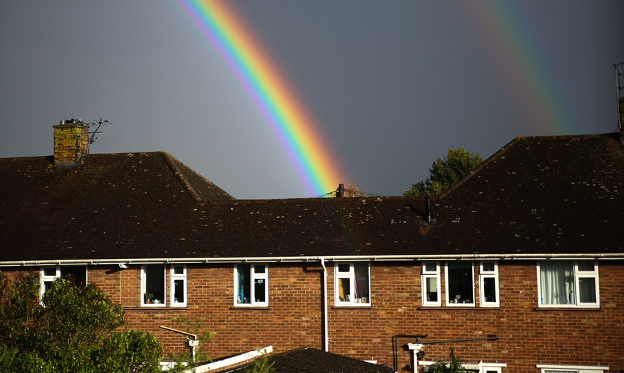 double rainbow in sky over housing estate
