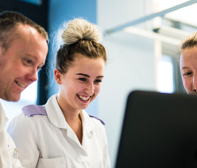 2 nurses and a young cadet nurse smiling looking at screen