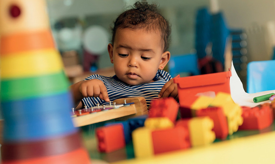 close up of baby playing with wooden toys